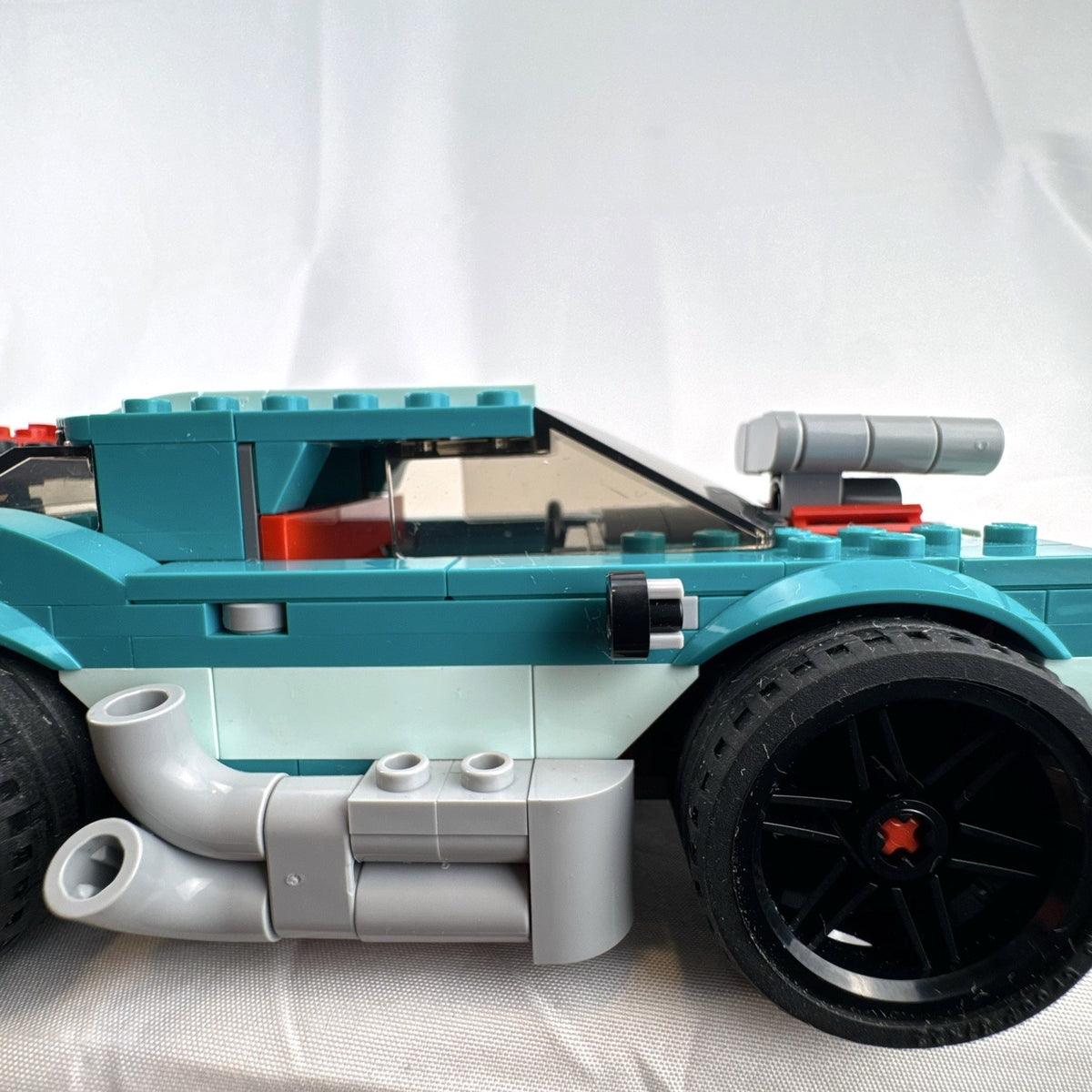 Assembled teal LEGO Creator 3-in-1 Street Racer car set 31127 with original box and instruction booklets