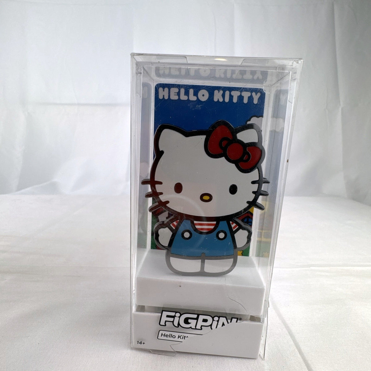 FiGPiN Sanrio Hello Kitty hard enamel pin in classic overalls encased in clear display box