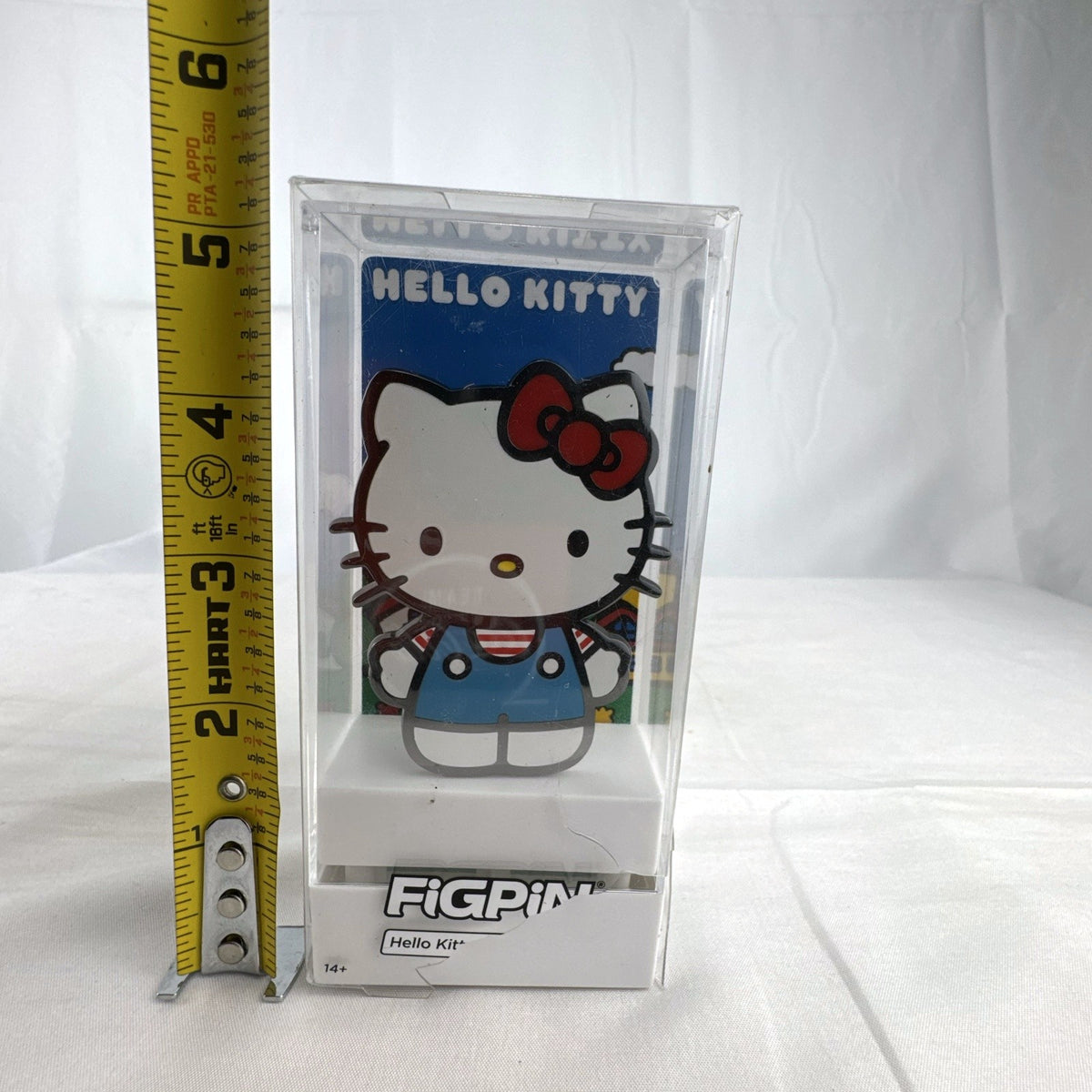 FiGPiN Sanrio Hello Kitty hard enamel pin in classic overalls encased in clear display box