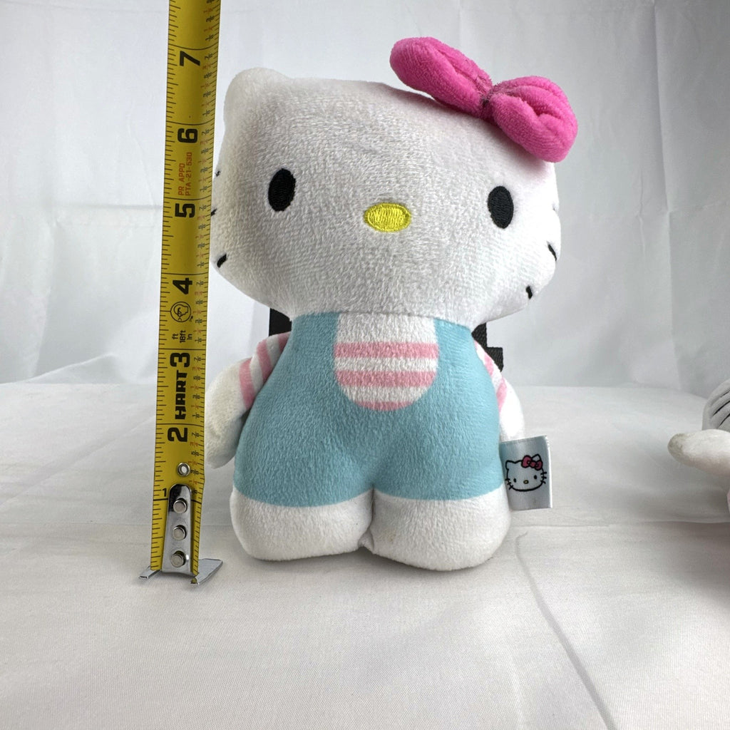 Pair of Sanrio Hello Kitty plush dolls wearing blue and pink overalls, measuring approximately 7 inches tall.