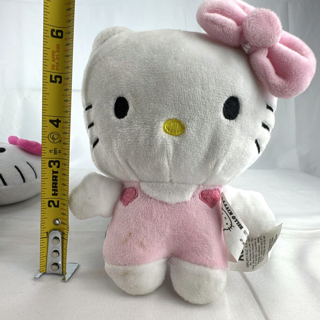 Pair of Sanrio Hello Kitty plush dolls wearing blue and pink overalls, measuring approximately 7 inches tall.