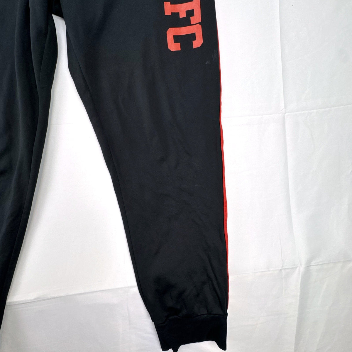 Manchester United men's black and red jogger track pants with club crest in size S