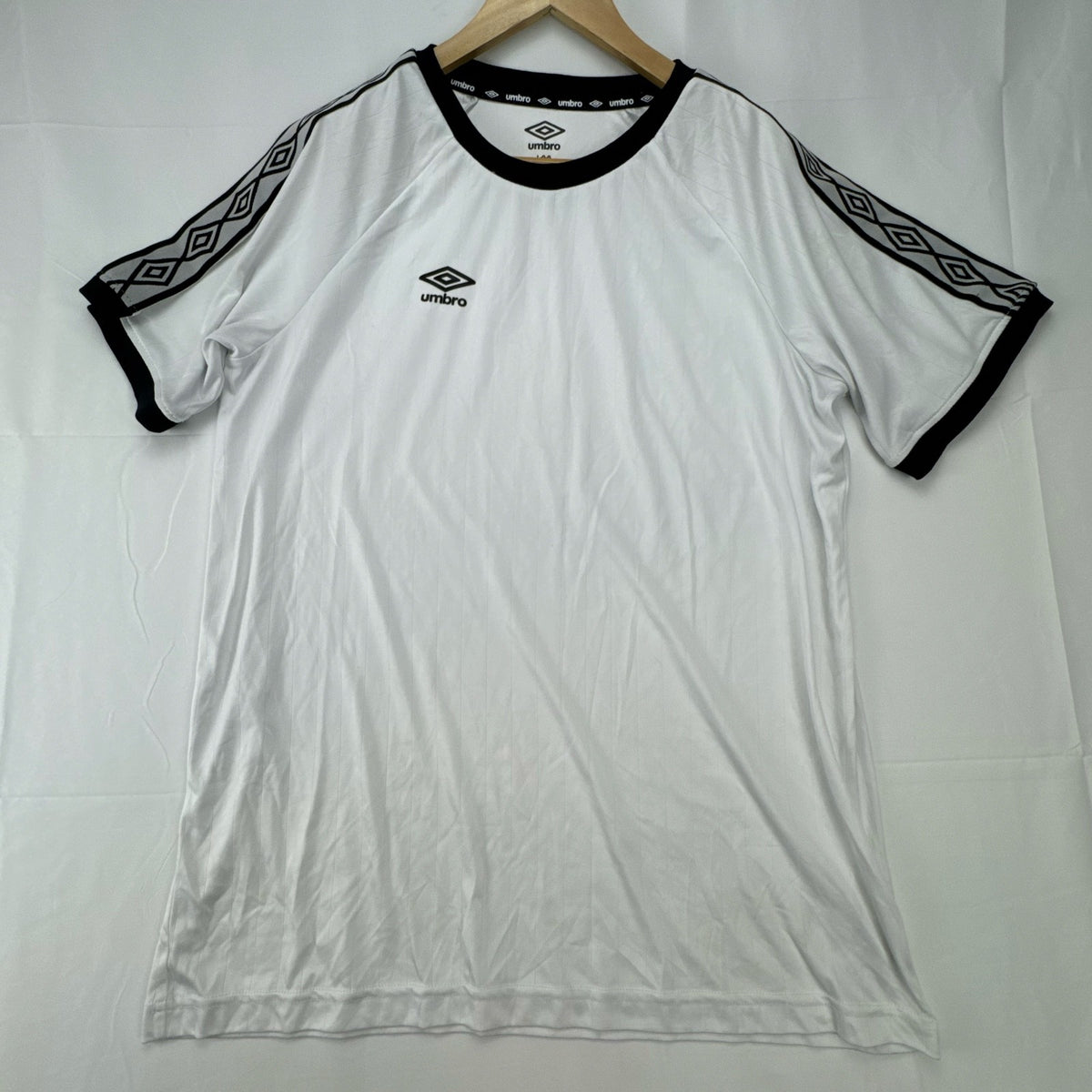White Umbro soccer jersey in size Large featuring black double diamond taped sleeves and crew neckline.