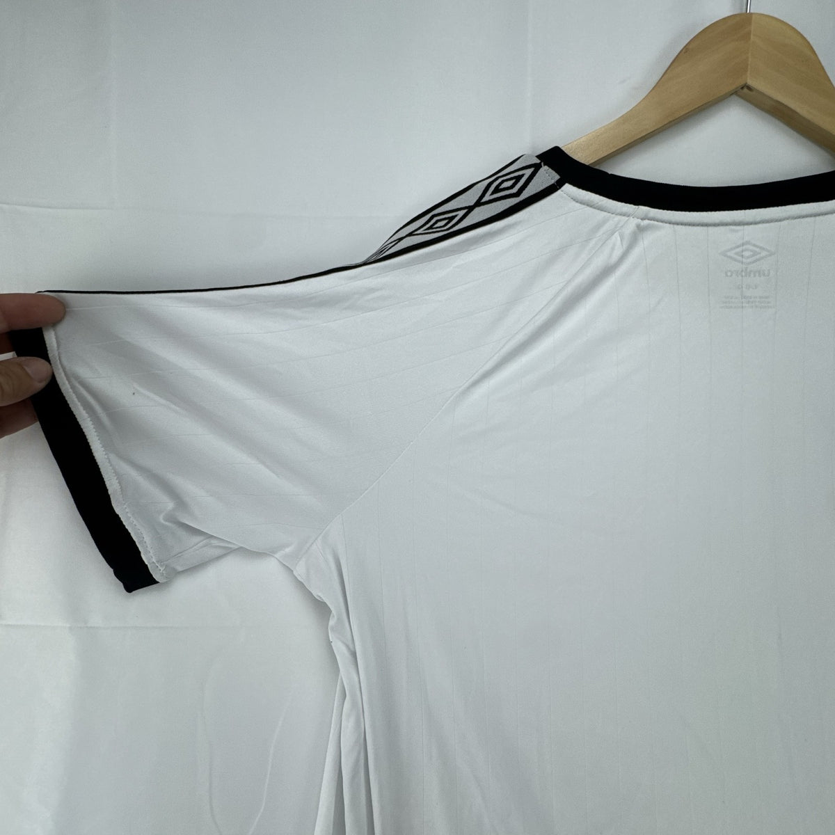 White Umbro soccer jersey in size Large featuring black double diamond taped sleeves and crew neckline.