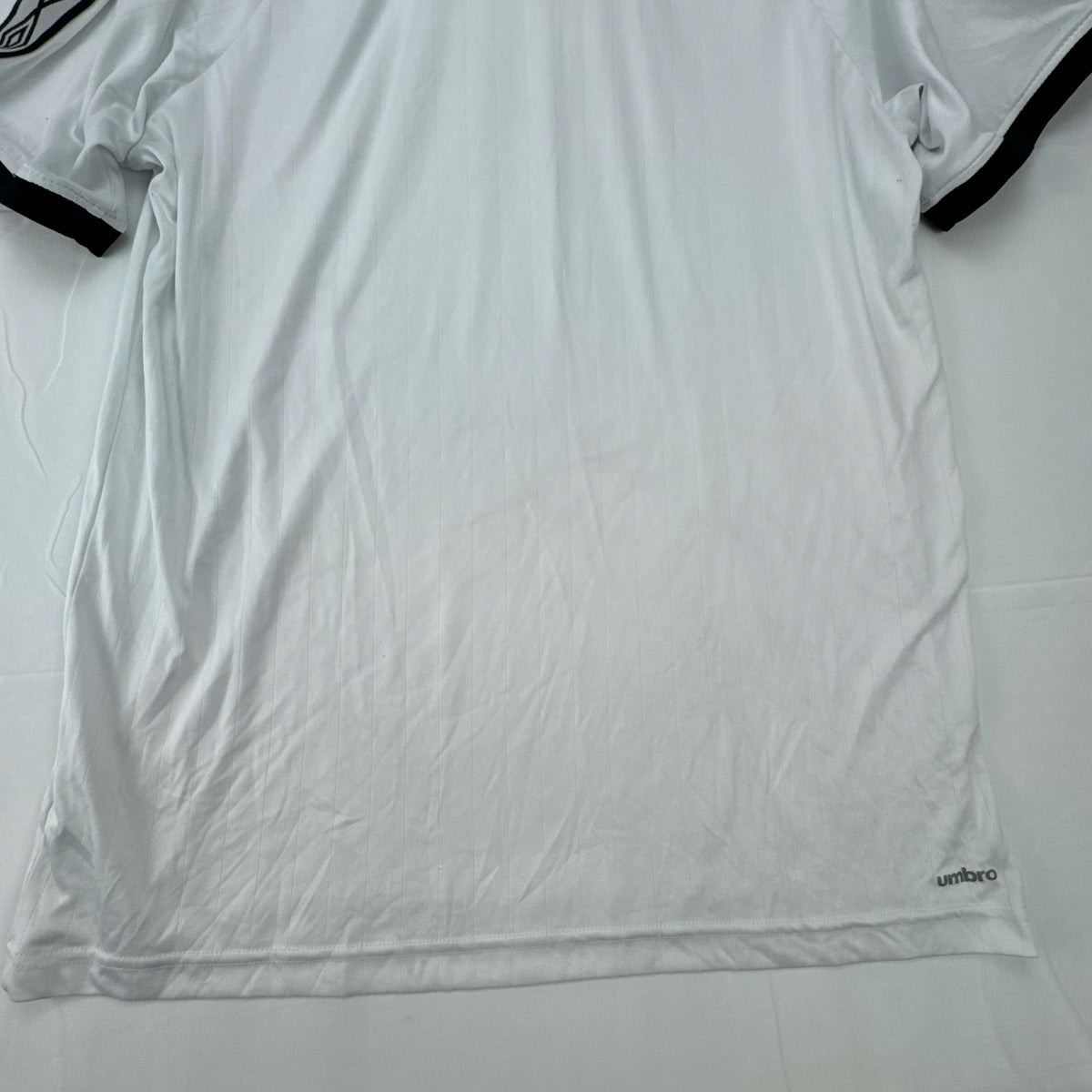 White Umbro soccer jersey in size Large featuring black double diamond taped sleeves and crew neckline.