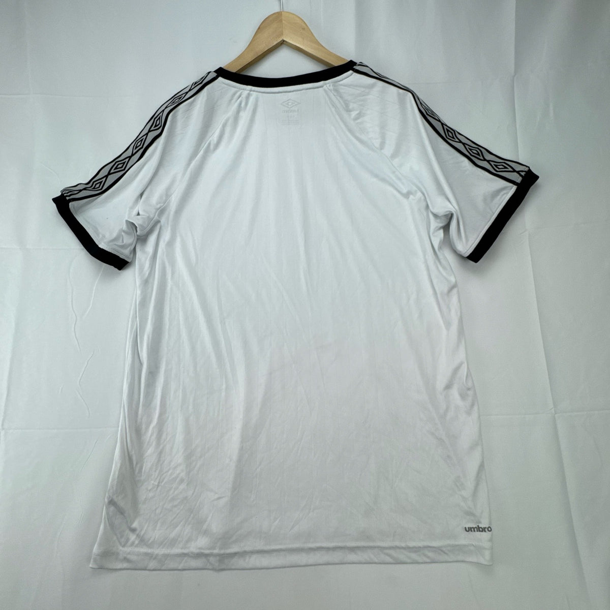 White Umbro soccer jersey in size Large featuring black double diamond taped sleeves and crew neckline.