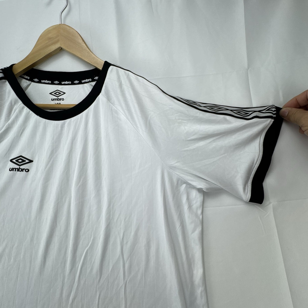 White Umbro soccer jersey in size Large featuring black double diamond taped sleeves and crew neckline.