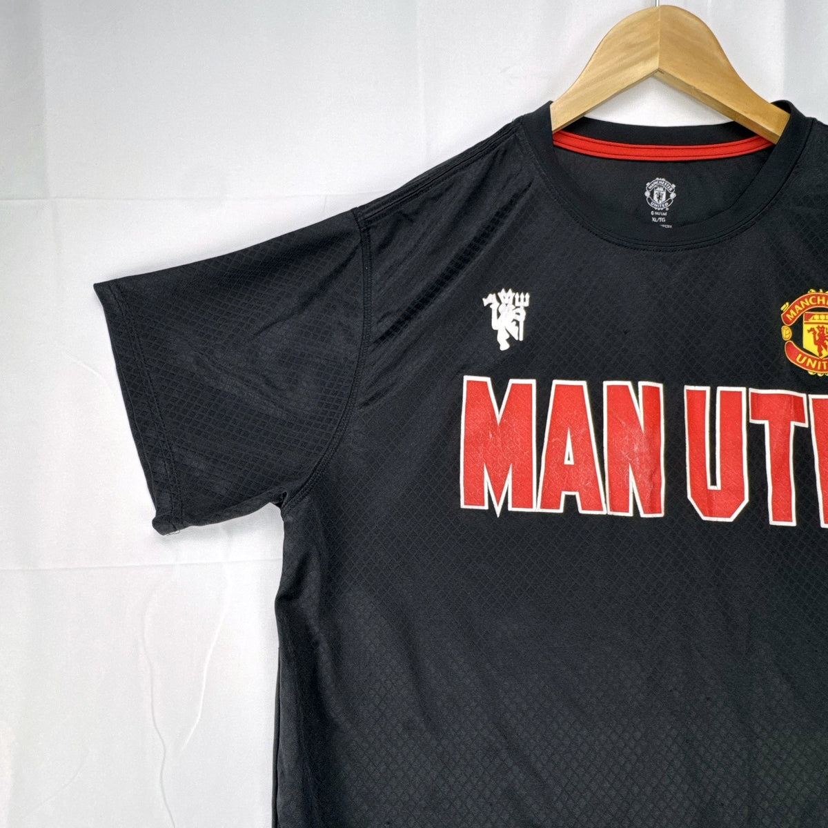 Front view of official Manchester United black short sleeve training jersey in men's size XL.