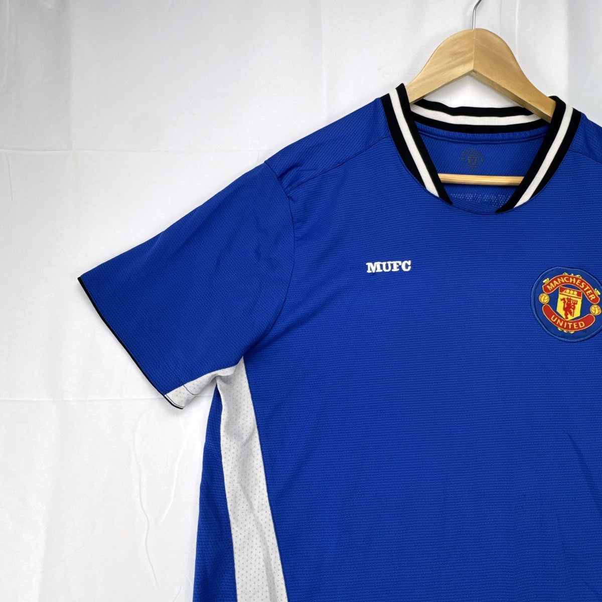 Manchester United men's large royal blue soccer jersey with embroidered chest crest and striped ribbed collar.