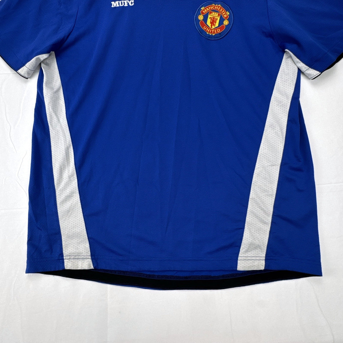 Manchester United men's large royal blue soccer jersey with embroidered chest crest and striped ribbed collar.
