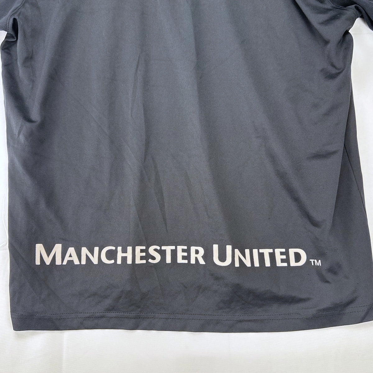 Manchester United men's soccer jersey in black with blue shoulder panels and embroidered crest