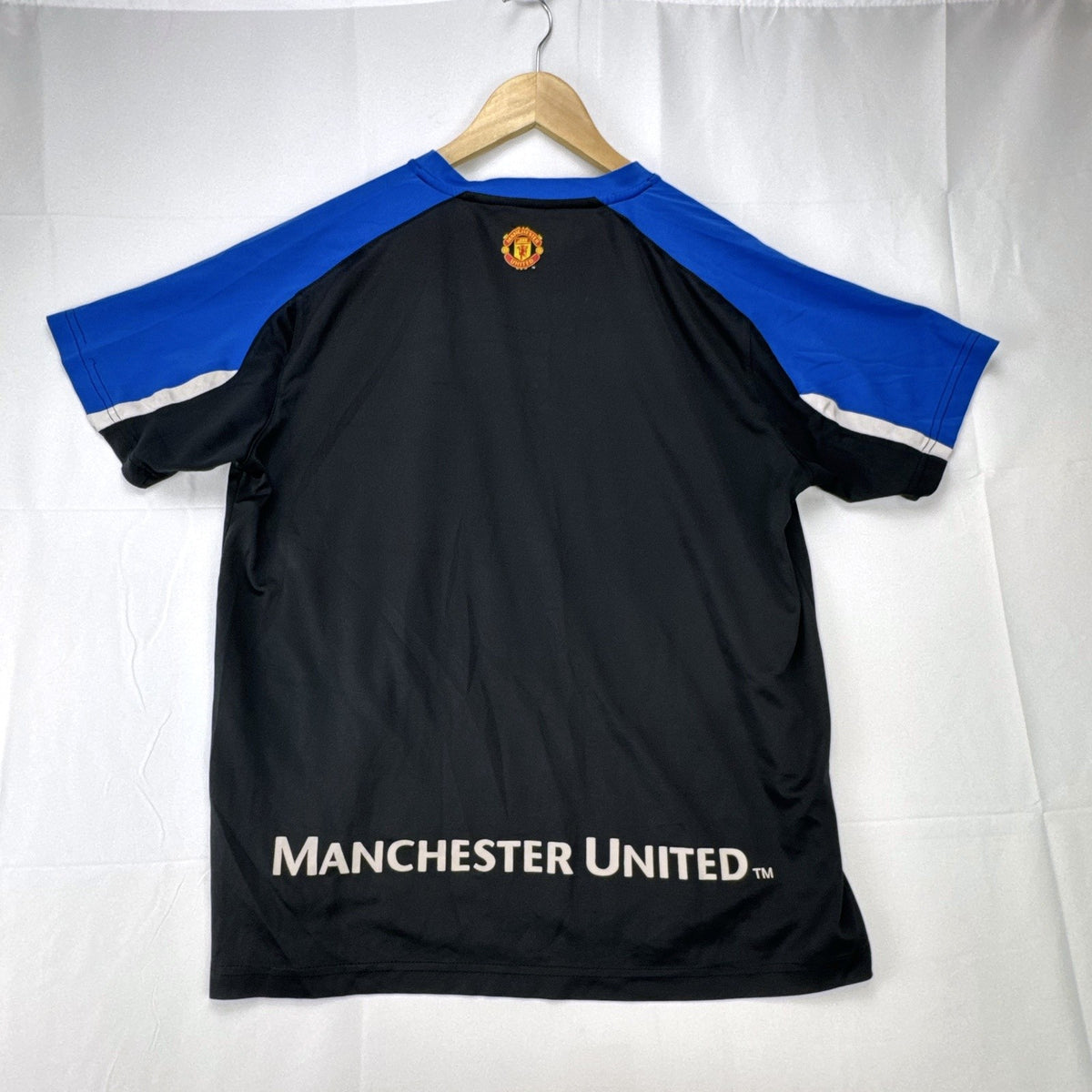 Manchester United men's soccer jersey in black with blue shoulder panels and embroidered crest