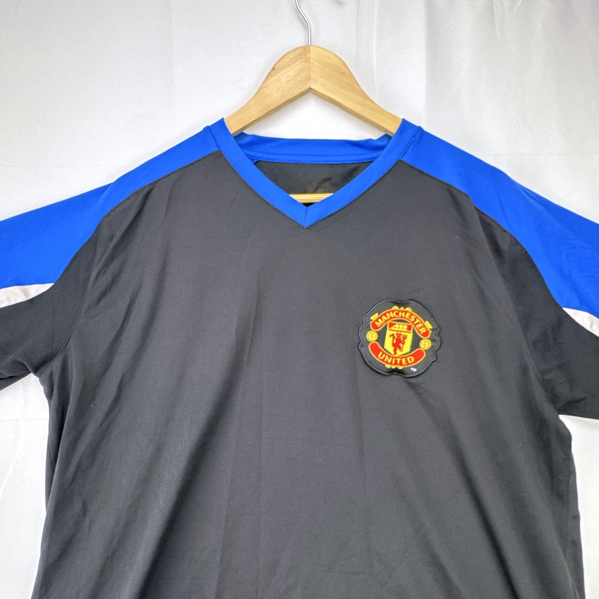 Manchester United men's soccer jersey in black with blue shoulder panels and embroidered crest