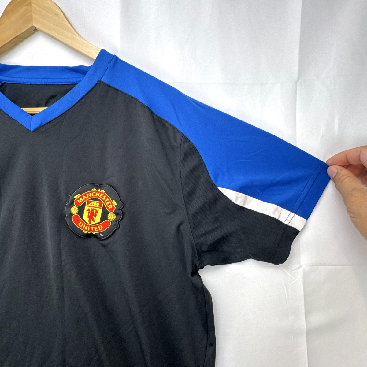 Manchester United men's soccer jersey in black with blue shoulder panels and embroidered crest