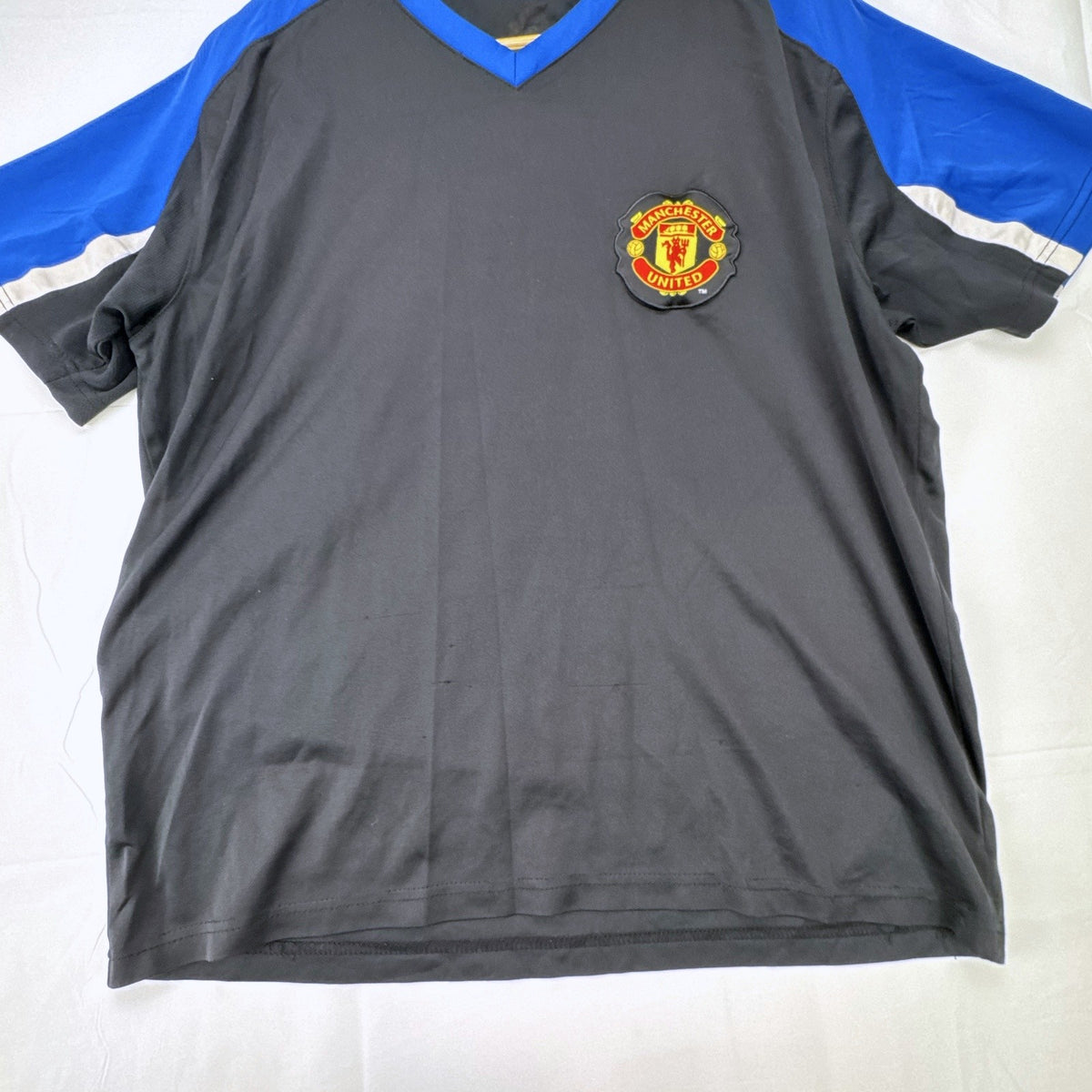 Manchester United men's soccer jersey in black with blue shoulder panels and embroidered crest