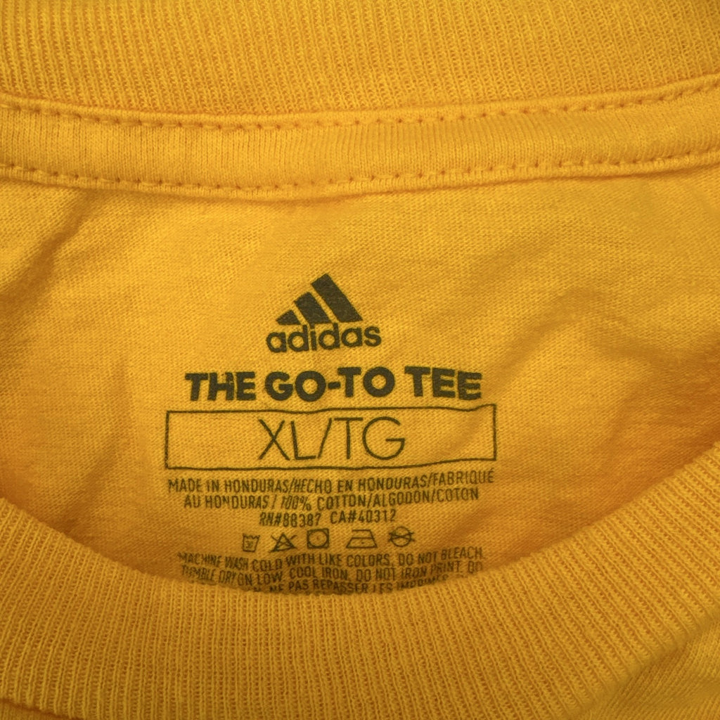 Front view of yellow adidas The Go-To graphic t-shirt in men's XL with black Badge of Sport logo