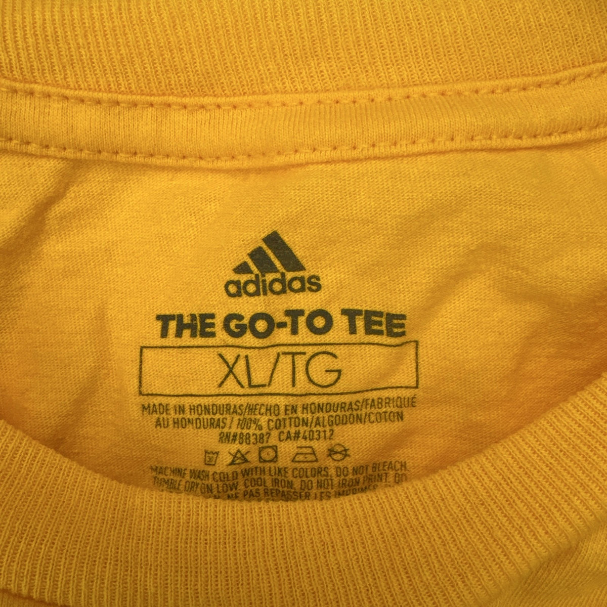Front view of yellow adidas The Go-To graphic t-shirt in men's XL with black Badge of Sport logo