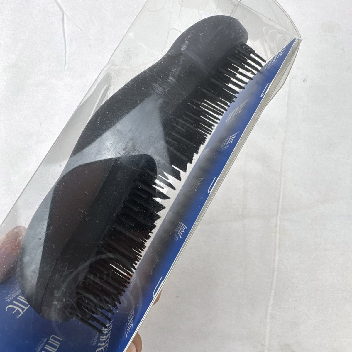 UNITE Pro-System black ergonomic palm detangler hairbrush in original clear box