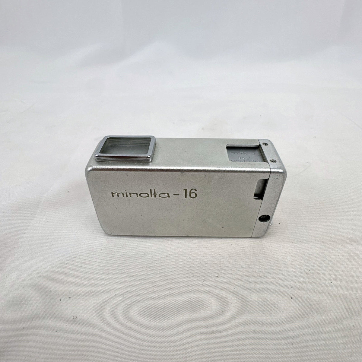 Vintage silver Minolta 16 II subminiature 16mm film camera showing Rokkor 22mm f/2.8 lens and metal push-pull body.