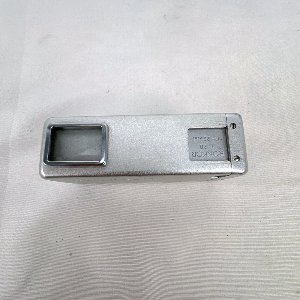 Vintage silver Minolta 16 II subminiature 16mm film camera showing Rokkor 22mm f/2.8 lens and metal push-pull body.