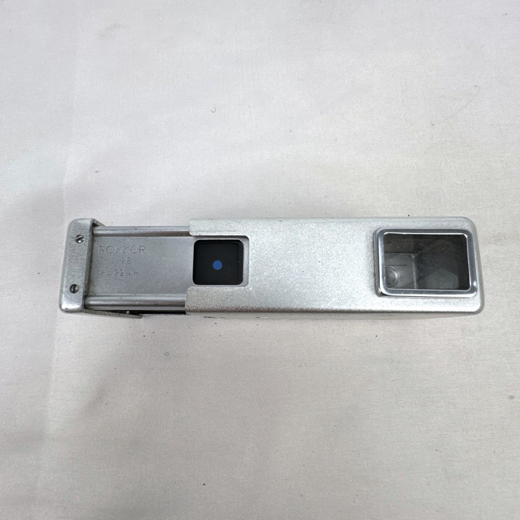 Vintage silver Minolta 16 II subminiature 16mm film camera showing Rokkor 22mm f/2.8 lens and metal push-pull body.