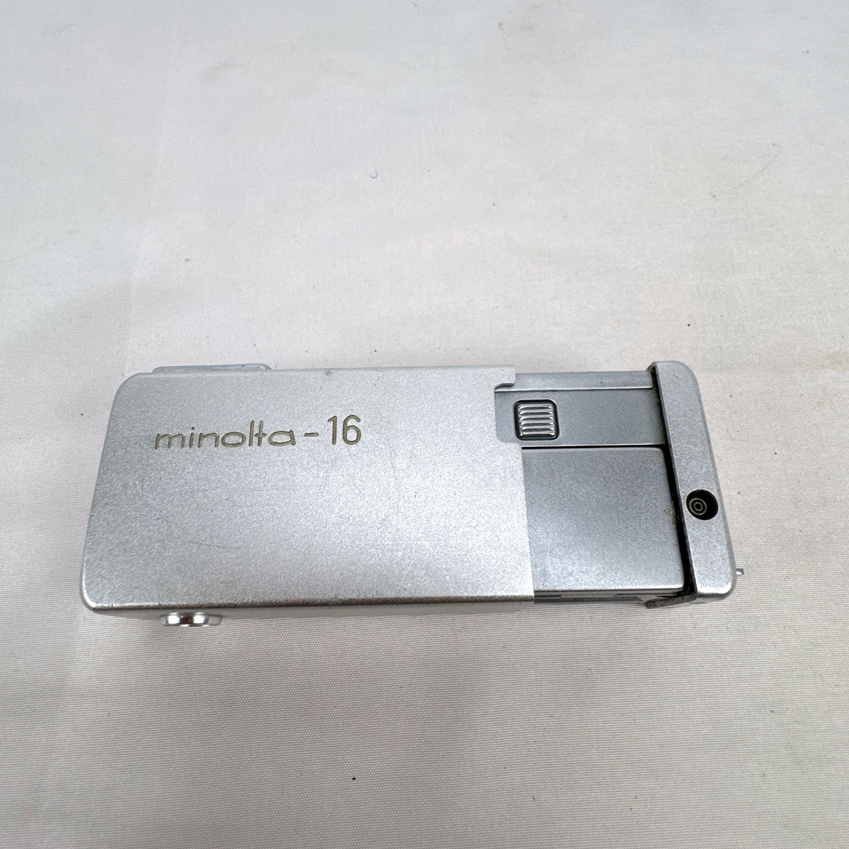 Vintage silver Minolta 16 II subminiature 16mm film camera showing Rokkor 22mm f/2.8 lens and metal push-pull body.