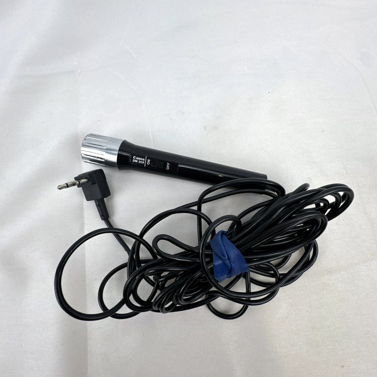 Black Canon DM 30R dynamic handheld microphone with chrome grille and attached 3.5mm cable