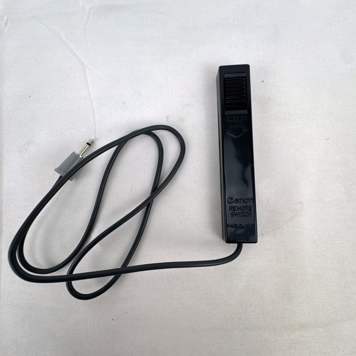 Black vintage Canon wired shutter release remote switch with 2.5mm connector plug and running lock.