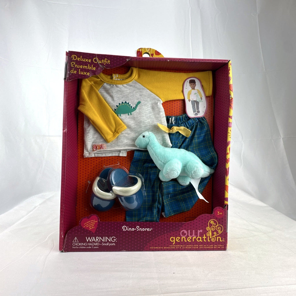 Our Generation Dino-Snores pajama outfit for 18-inch dolls in packaging with plaid pants and dinosaur plush.