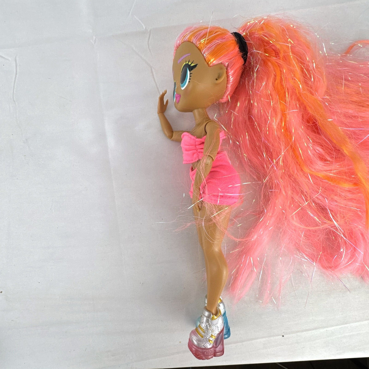 MGA L.O.L. Surprise! O.M.G. Lights Dazzle fashion doll with neon pink tinsel hair and platform sneakers.