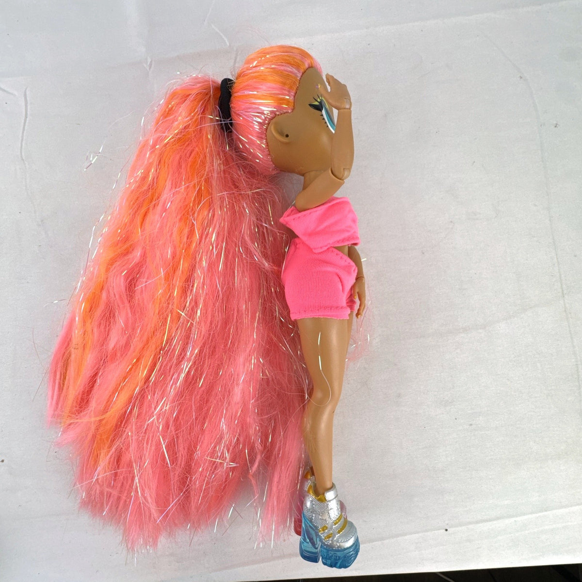 MGA L.O.L. Surprise! O.M.G. Lights Dazzle fashion doll with neon pink tinsel hair and platform sneakers.