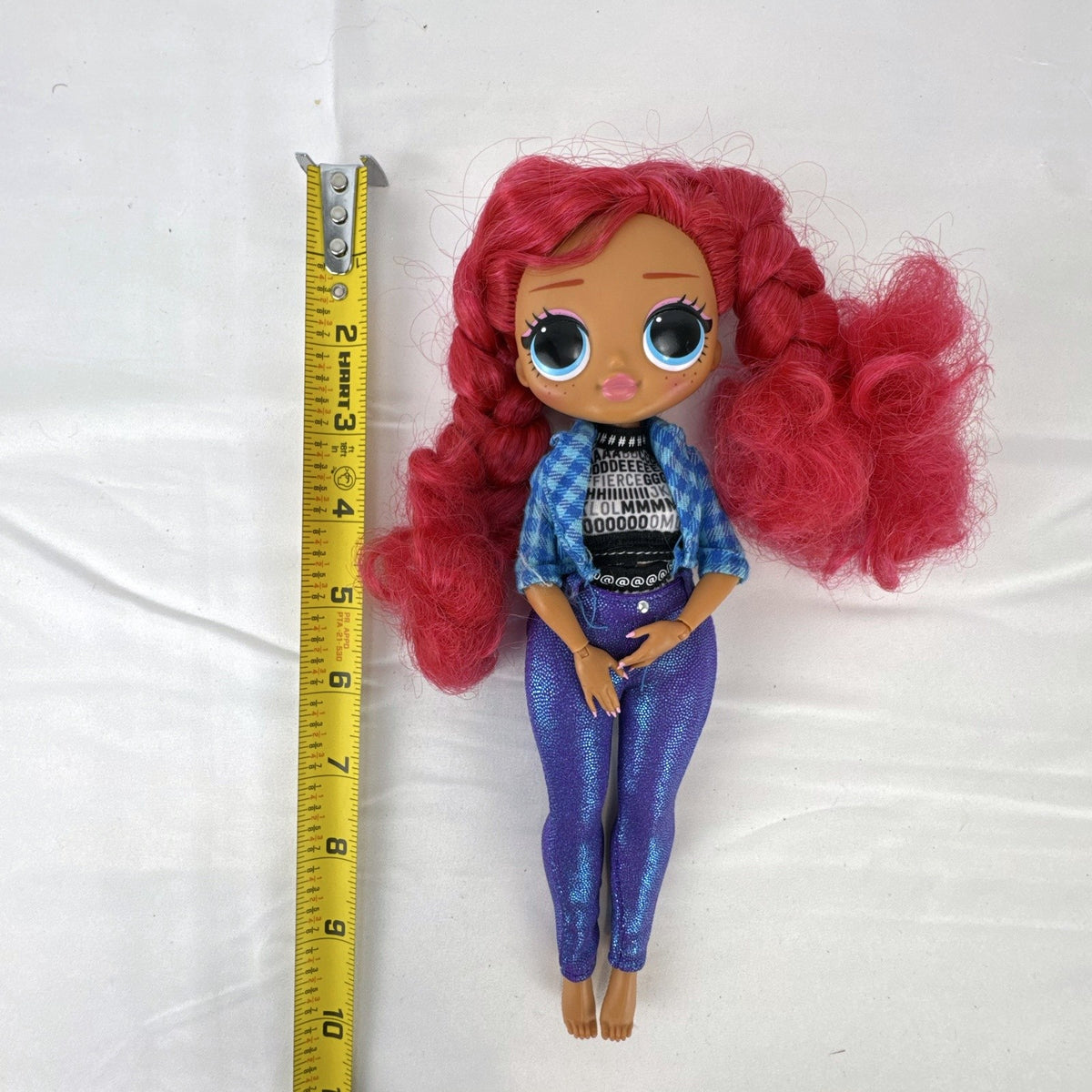 MGA L.O.L. Surprise! O.M.G. Downtown B.B. 10-inch doll with pink curly hair in blue plaid jacket and purple pants