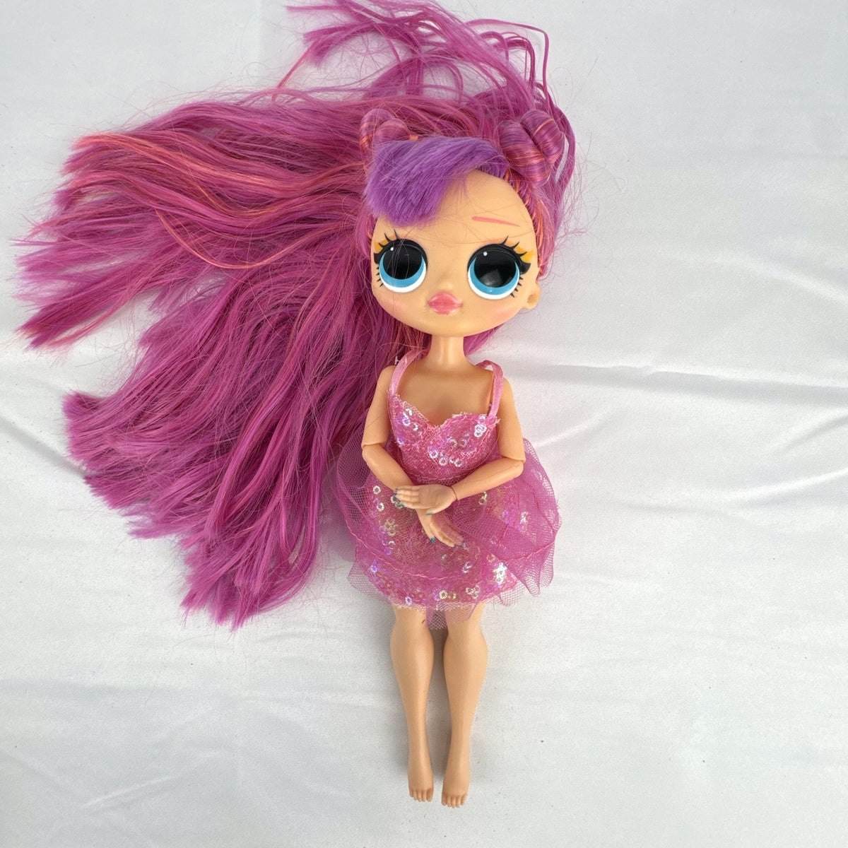 MGA Entertainment L.O.L. Surprise O.M.G. Lights Dazzle 10-inch fashion doll with pink hair in a sparkly sequin dress.