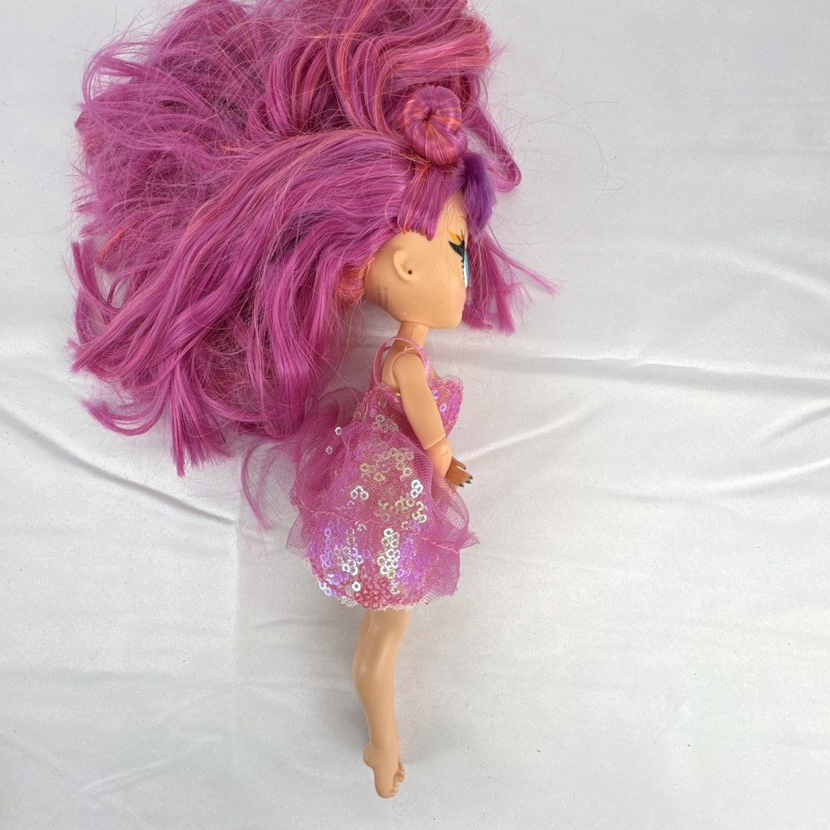 MGA Entertainment L.O.L. Surprise O.M.G. Lights Dazzle 10-inch fashion doll with pink hair in a sparkly sequin dress.
