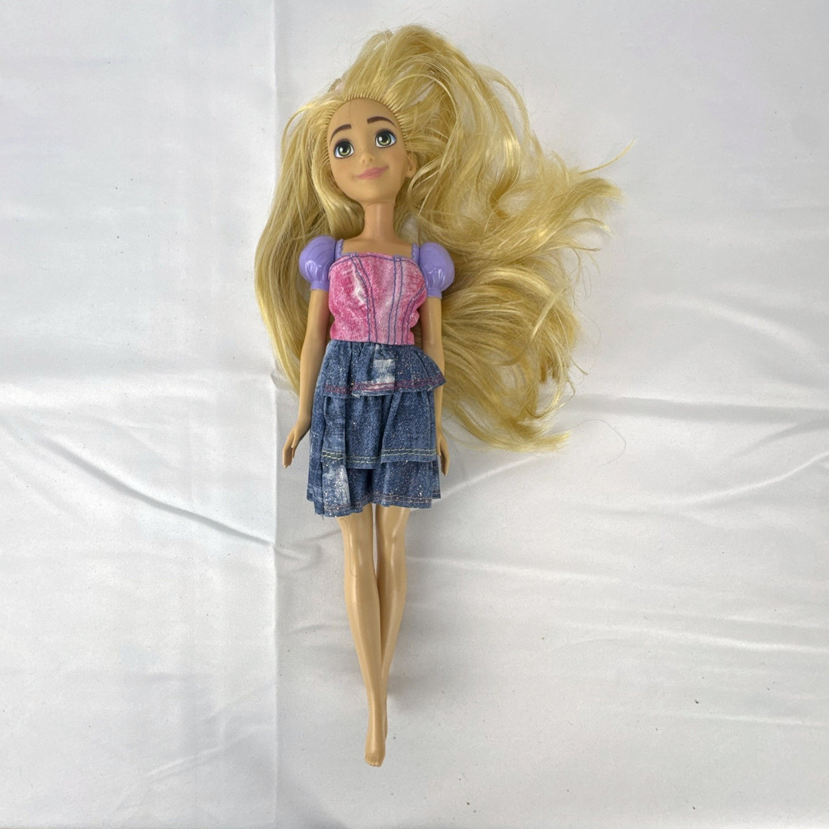 Mattel Disney Princess Rapunzel 11-inch fashion doll with long blonde hair and tiered skirt.