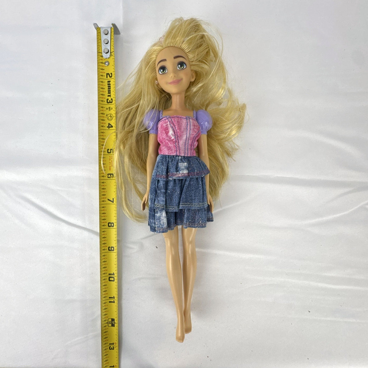 Mattel Disney Princess Rapunzel 11-inch fashion doll with long blonde hair and tiered skirt.