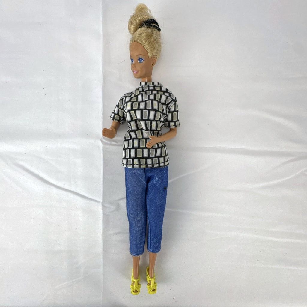 Vintage Mattel Barbie 12-inch doll with blonde hair bun updo, geometric top, blue cropped pants, and yellow platform heels.