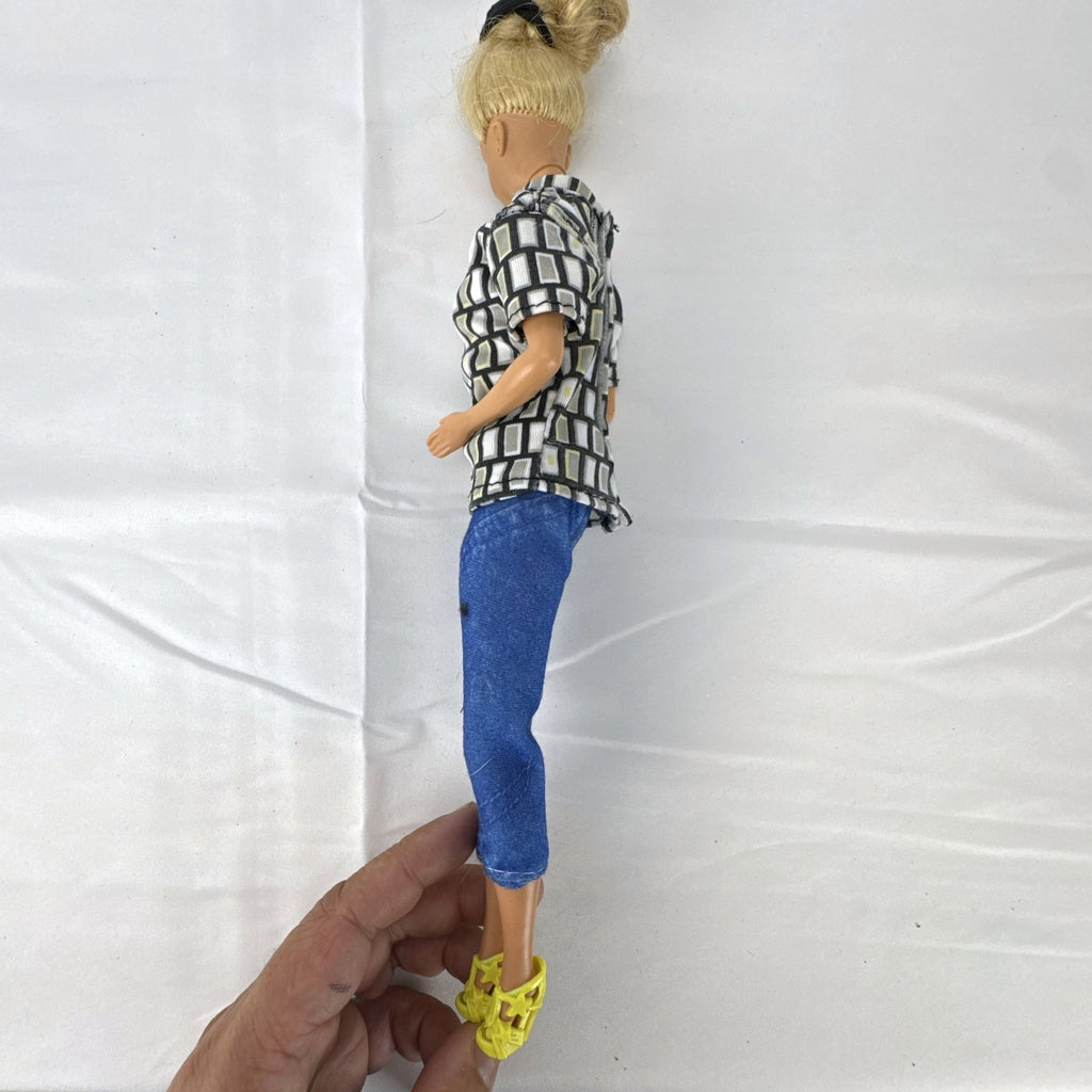 Vintage Mattel Barbie 12-inch doll with blonde hair bun updo, geometric top, blue cropped pants, and yellow platform heels.