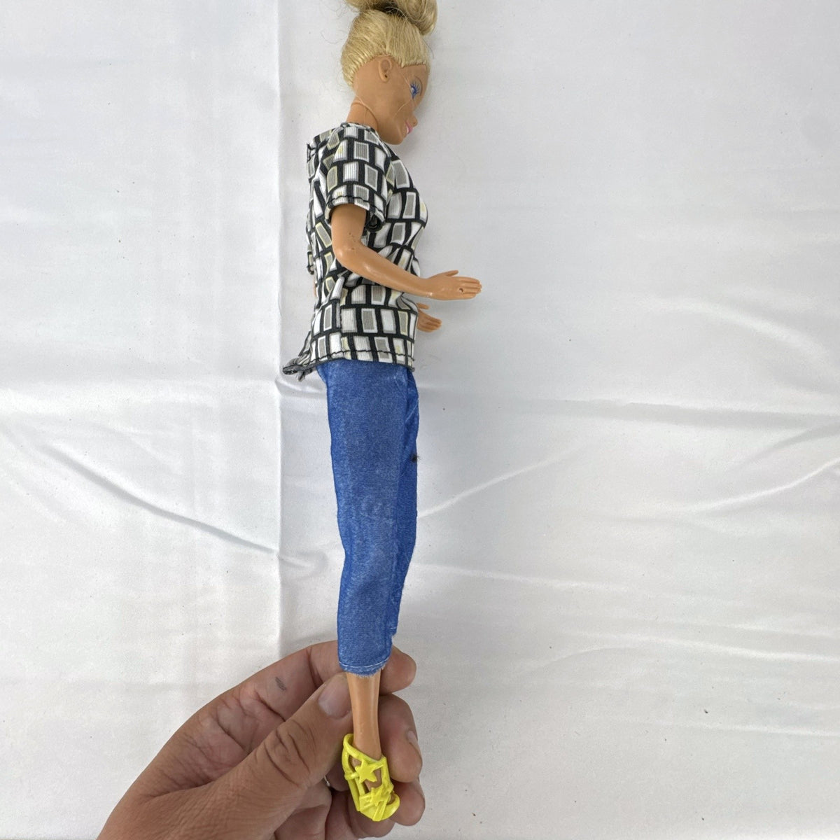 Vintage Mattel Barbie 12-inch doll with blonde hair bun updo, geometric top, blue cropped pants, and yellow platform heels.