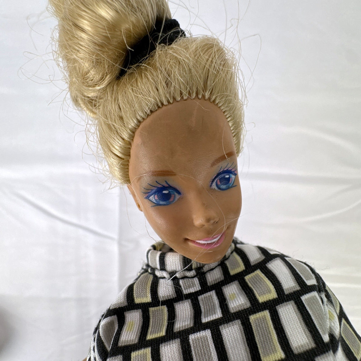 Vintage Mattel Barbie 12-inch doll with blonde hair bun updo, geometric top, blue cropped pants, and yellow platform heels.