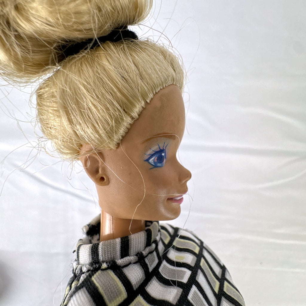 Vintage Mattel Barbie 12-inch doll with blonde hair bun updo, geometric top, blue cropped pants, and yellow platform heels.
