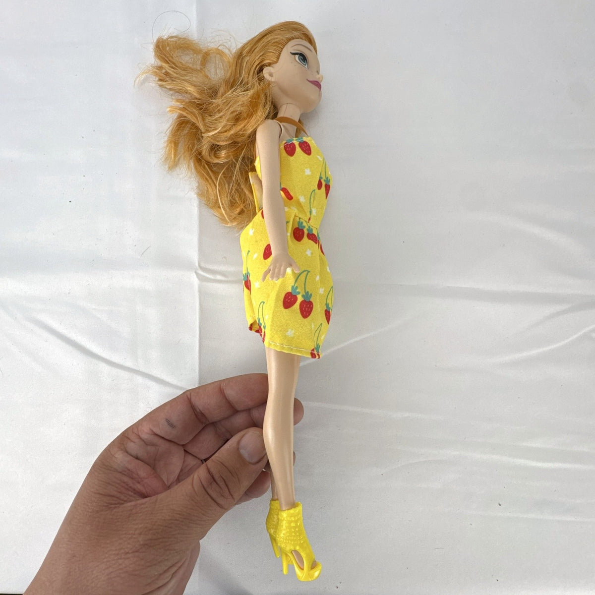 Mattel Disney Frozen Princess Anna 11-inch fashion doll wearing yellow strawberry dress and ankle booties