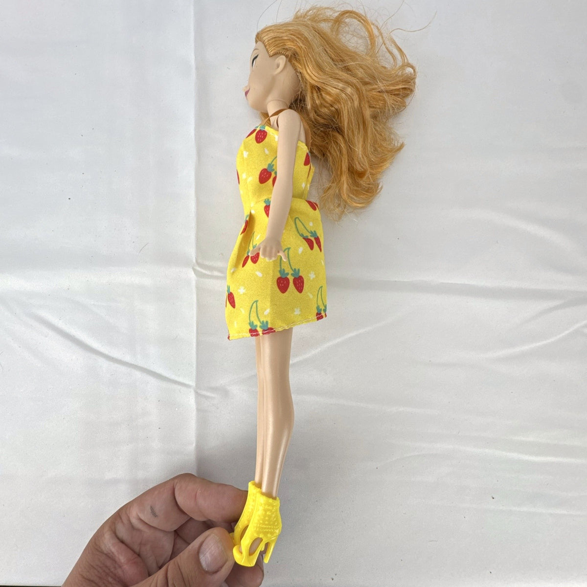 Mattel Disney Frozen Princess Anna 11-inch fashion doll wearing yellow strawberry dress and ankle booties
