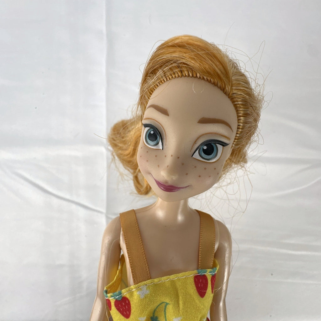 Mattel Disney Frozen Princess Anna 11-inch fashion doll wearing yellow strawberry dress and ankle booties