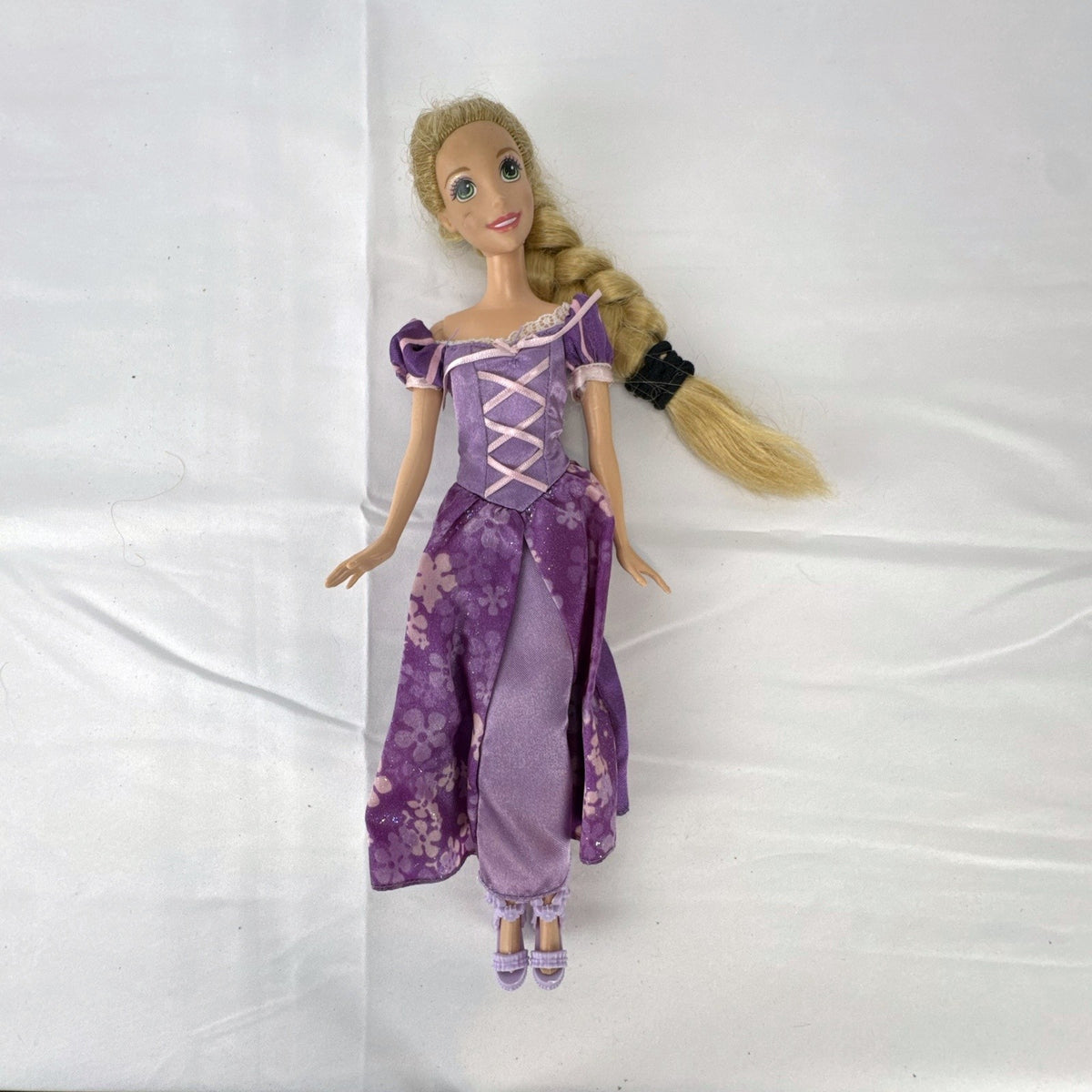 Mattel Disney Princess Rapunzel 11-inch doll wearing purple floral dress and shoes with braided blonde hair