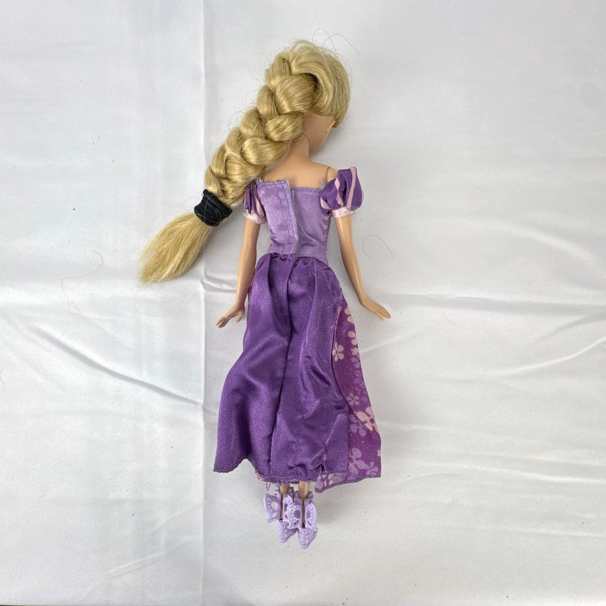 Mattel Disney Princess Rapunzel 11-inch doll wearing purple floral dress and shoes with braided blonde hair