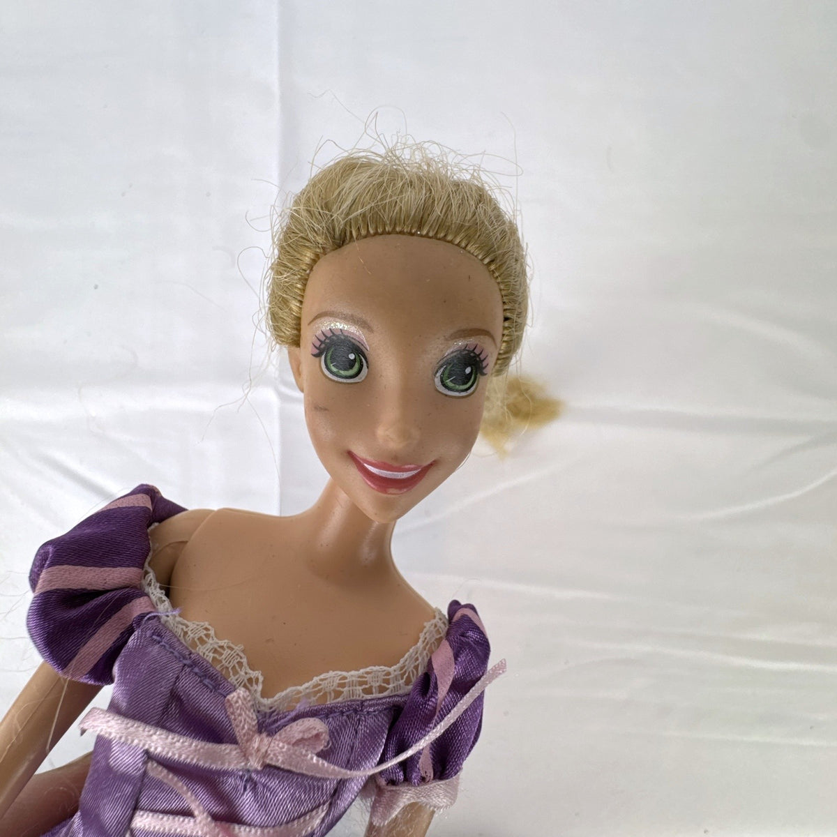 Mattel Disney Princess Rapunzel 11-inch doll wearing purple floral dress and shoes with braided blonde hair