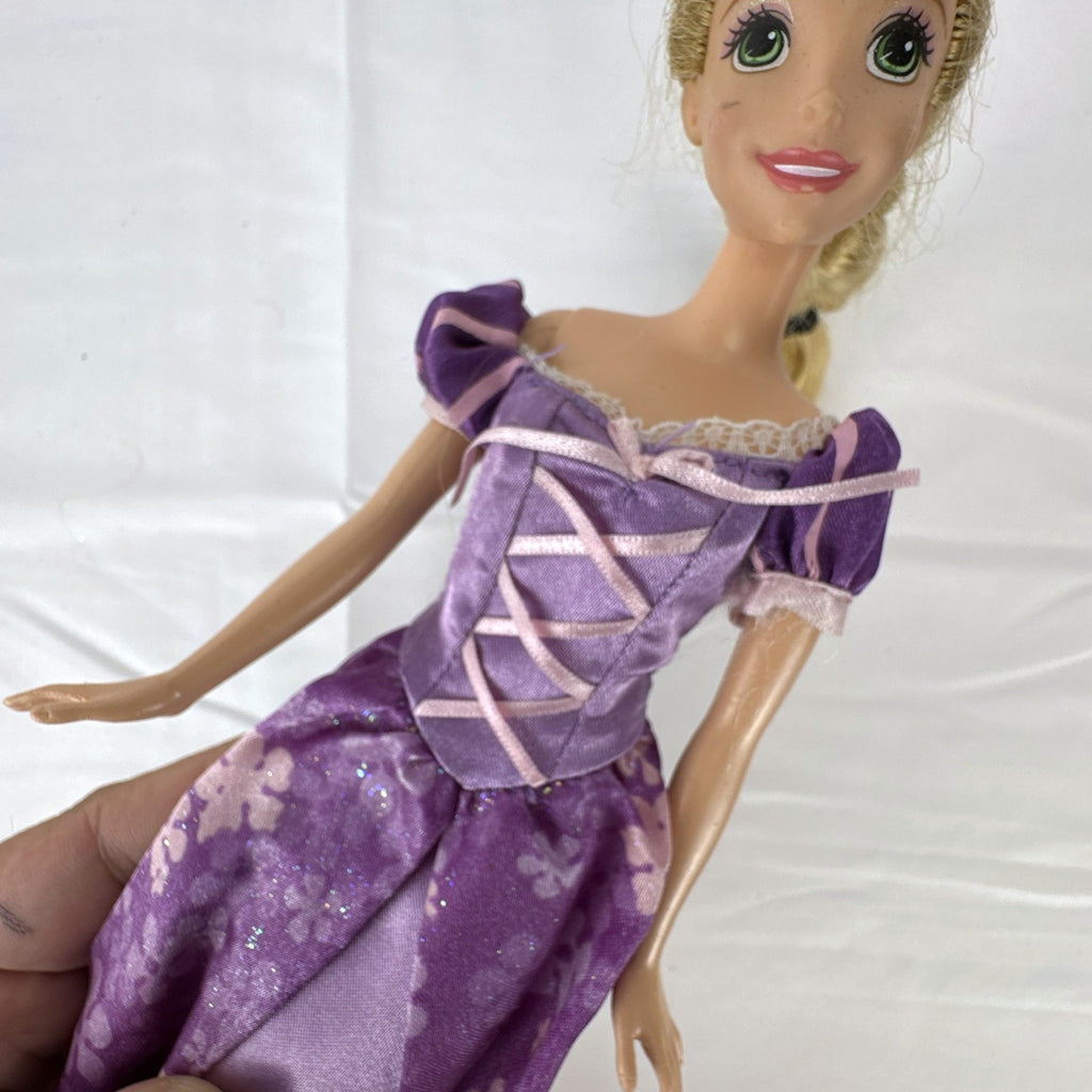 Mattel Disney Princess Rapunzel 11-inch doll wearing purple floral dress and shoes with braided blonde hair