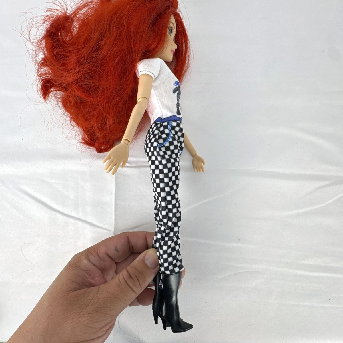 Articulated 11-inch Disney Ariel fashion doll with red hair in casual checkered pants and graphic t-shirt