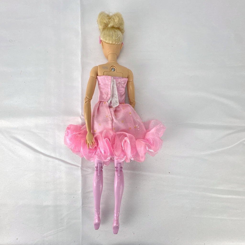 Mattel Barbie 12-inch articulated ballerina doll wearing a pink ruffled tutu dress with blonde bun hair.